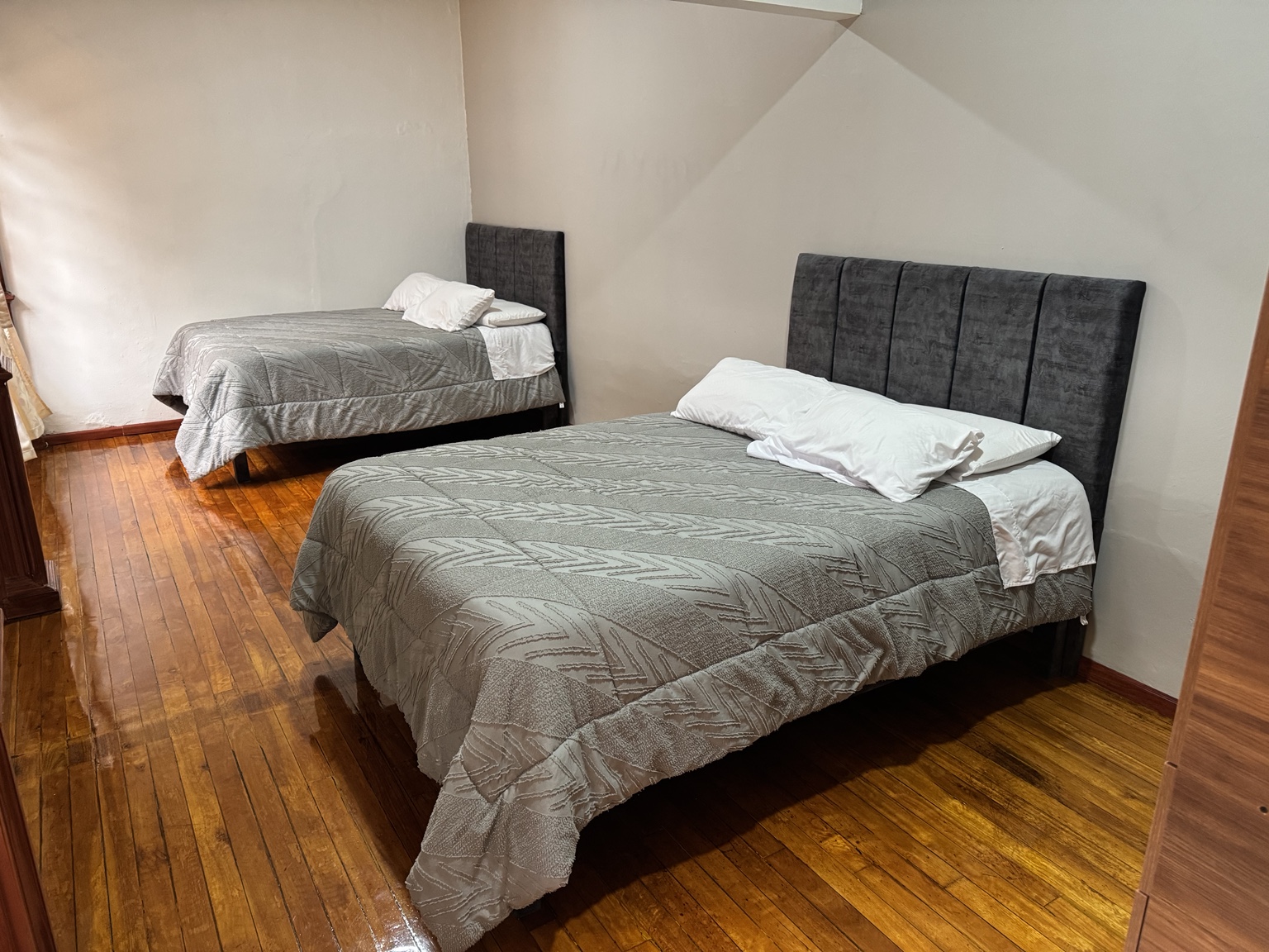 The two beds in Suite 4 with wooden floors
